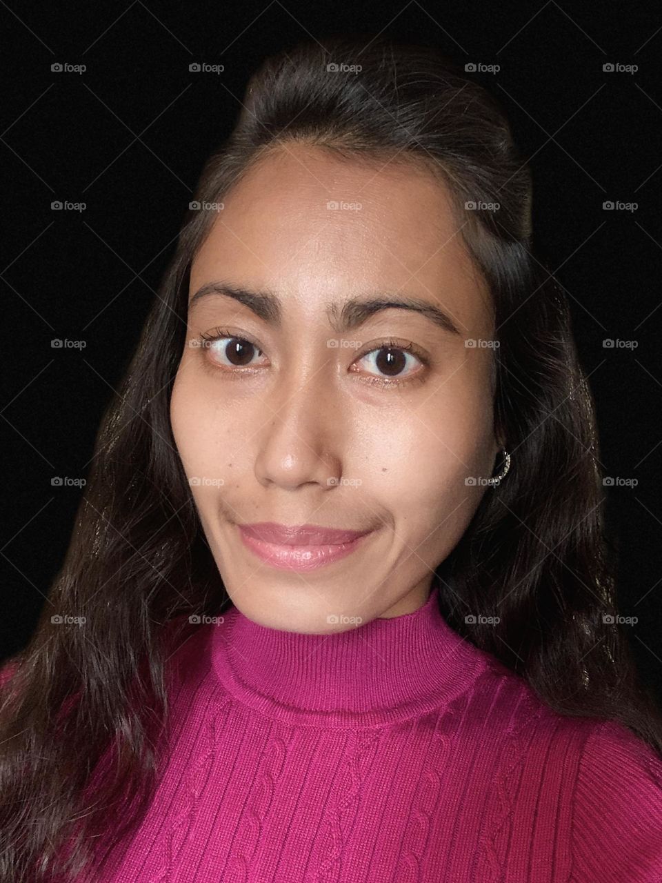 Portrait of a young woman wearing magenta shirt.