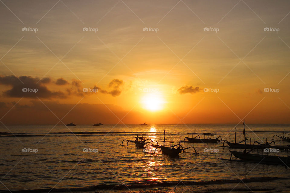 fisherman boath's silhouette on the beach when sun is goes down