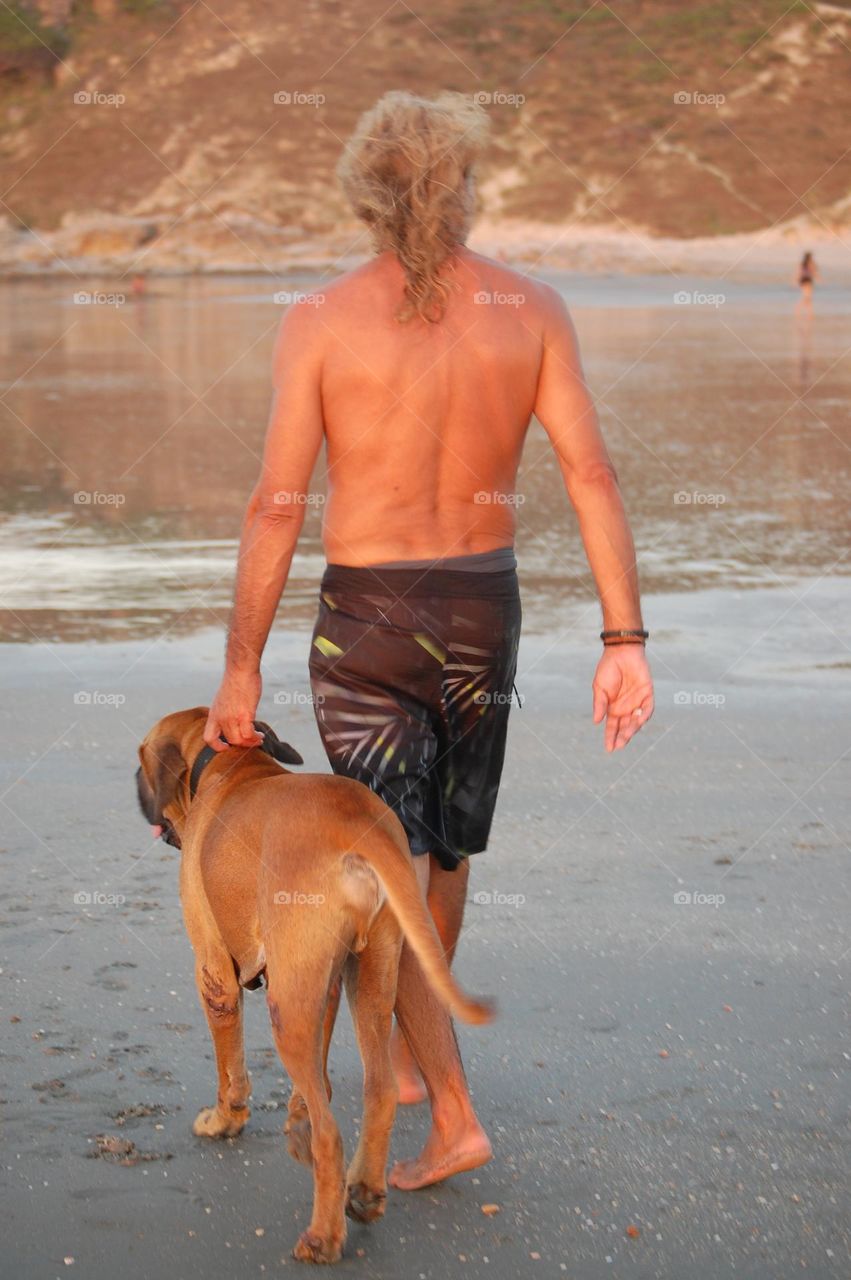 Man with long hair walking with dog
