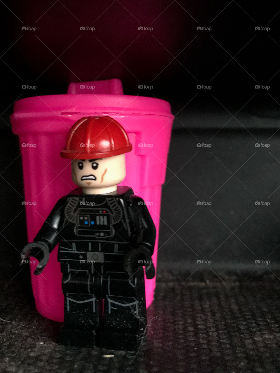 Taking out the trash! A just-for-fun photo of a mini Lego man and a somewhat larger hot pink trash can. 