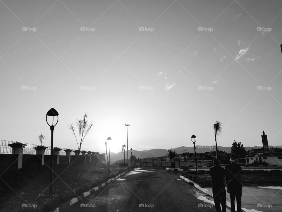 Rear view of couple walking on empty road