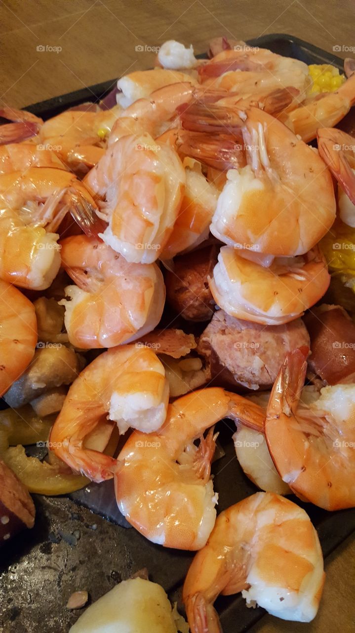 Cajun shrimp boil with sausage, corn and mushrooms, closeup.