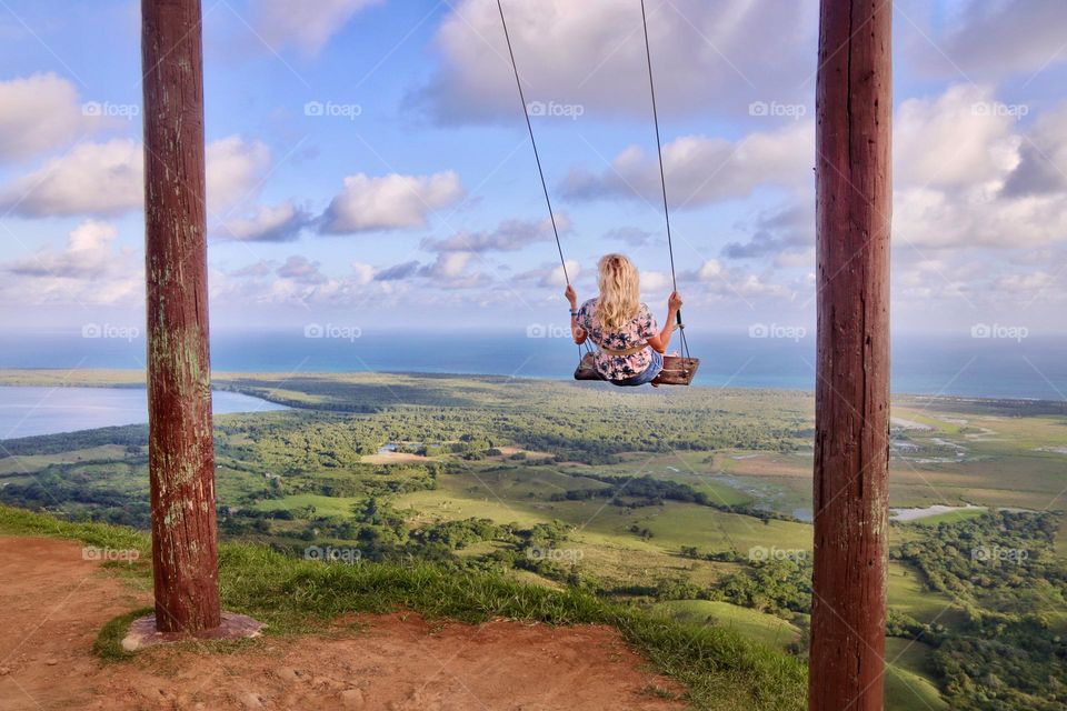 blond woman on a swing view from the mountain