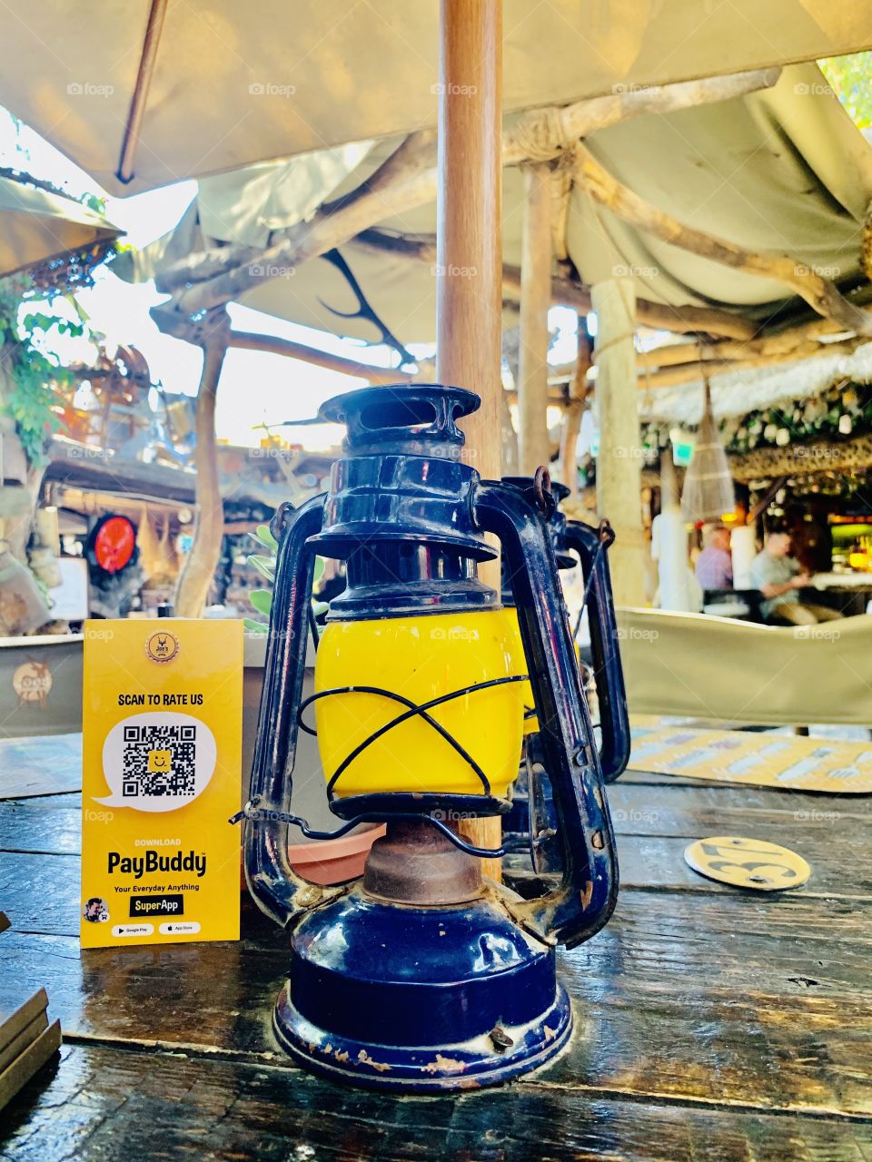 An old yellow and blue paraffin lamp on a dinner table at a scrapyard themed restaurant.