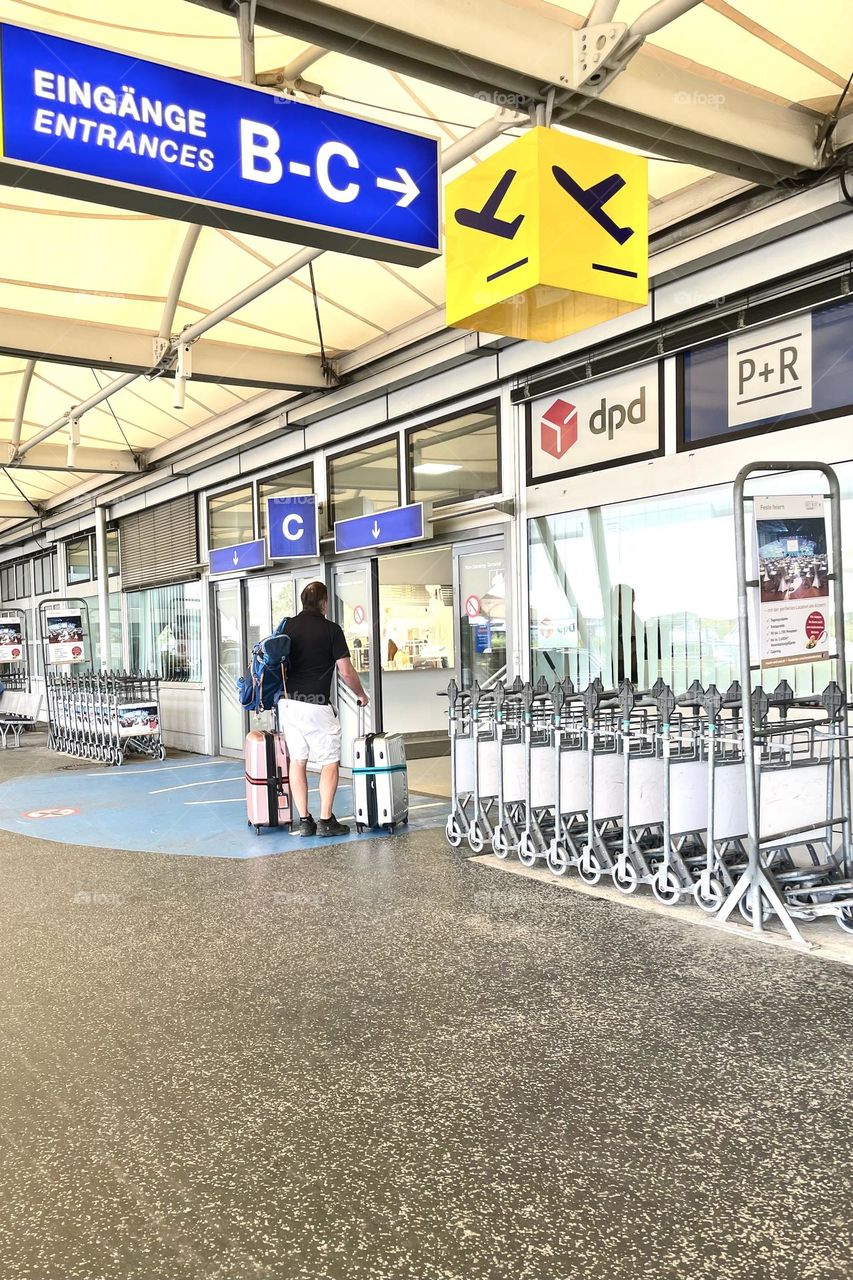 Man with his bags at the entrance on the airport 
