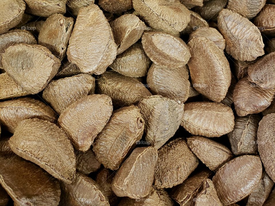 Closeup of details and texture of a pile of  Brazil nuts in their shells at the local market