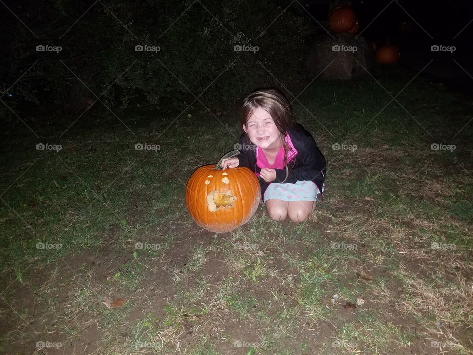 carved pumpkin with young girl