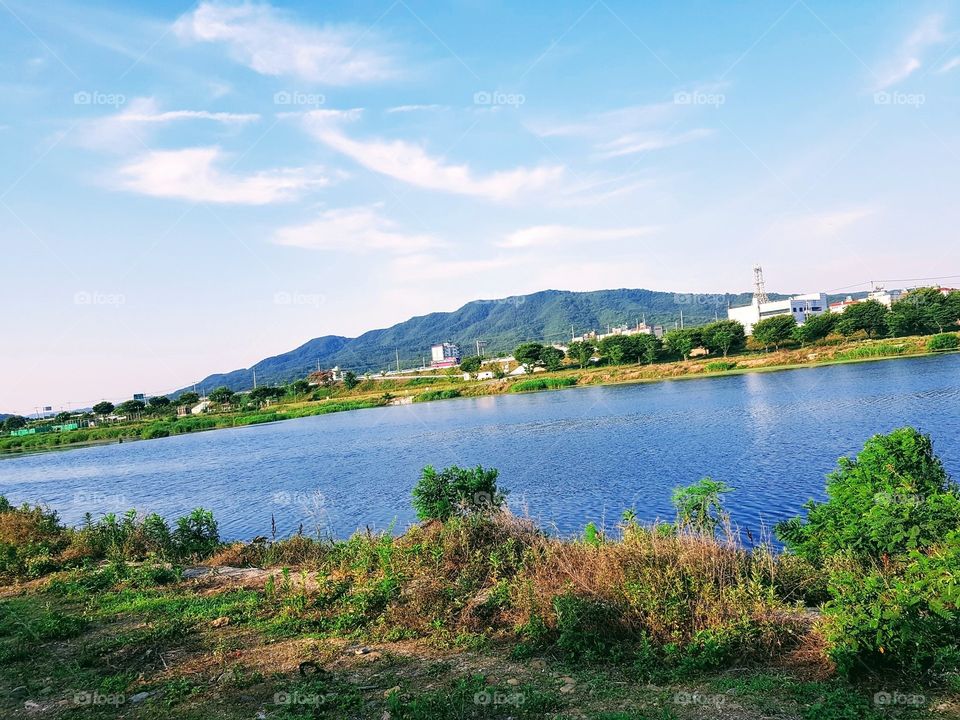 The Beautiful Sight In South Korea where yoU can see green fields and big clear water lake, over looking mountain and relaxing nature.