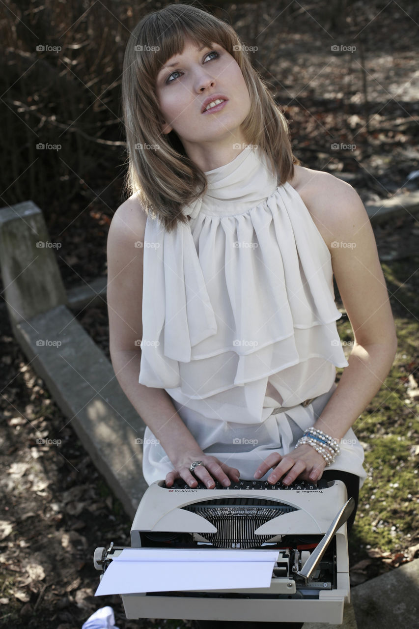 girl on vintage typewriter. 6young blonde woman in the park with typewriter