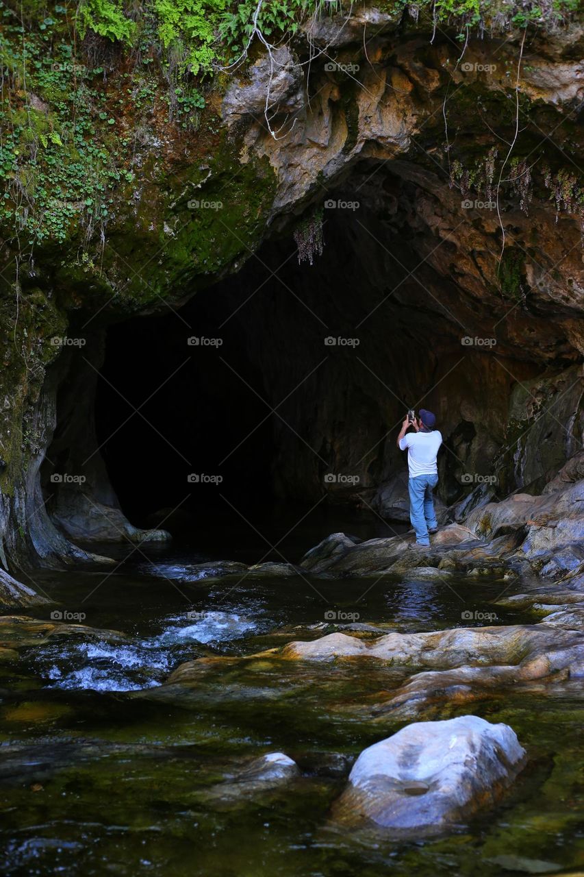 Man Taking a Picture of a Cave