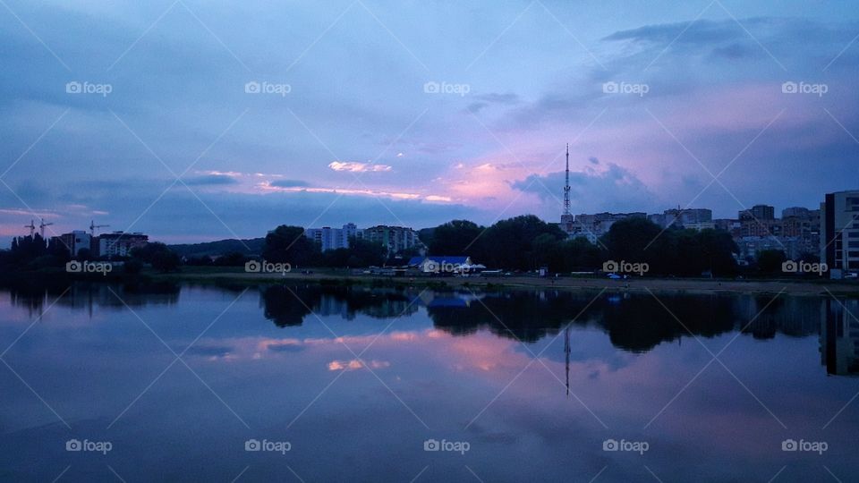 Reflection on the blue river and sky with pink clouds