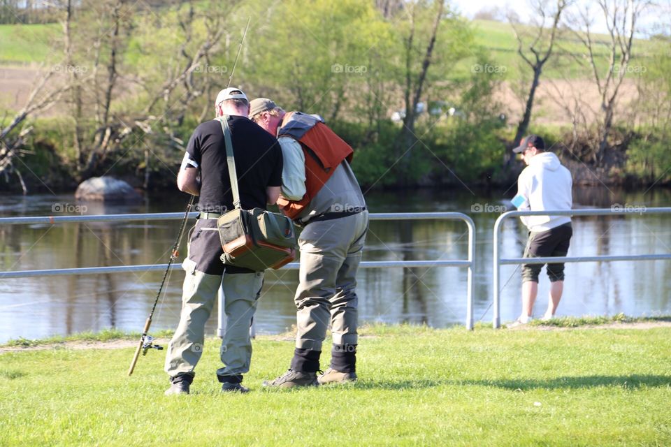 Three men fishing by the river