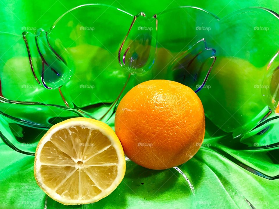 Orange and Lemon in GlassBowl on Green
