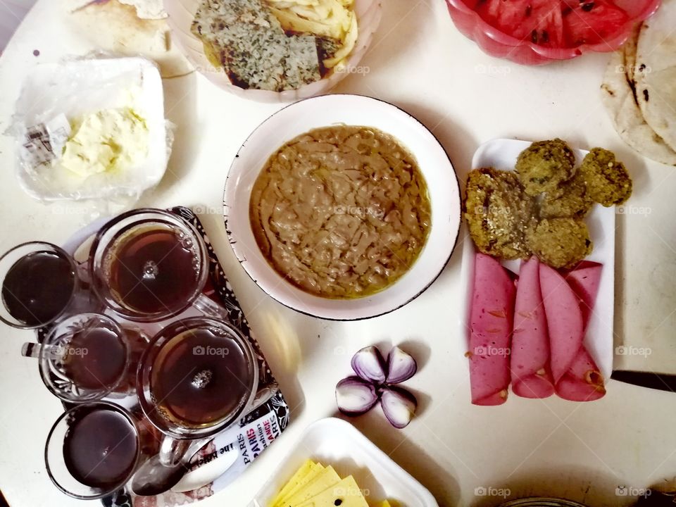 A popular Egyptian breakfast made of Egyptian beans, peppers, omelets, French fries, cheese, bread, lanchun and watermelon