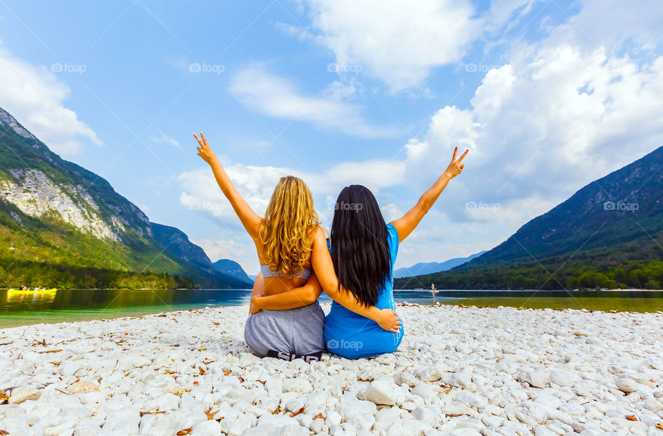 Rear view of girl making v sign at beach