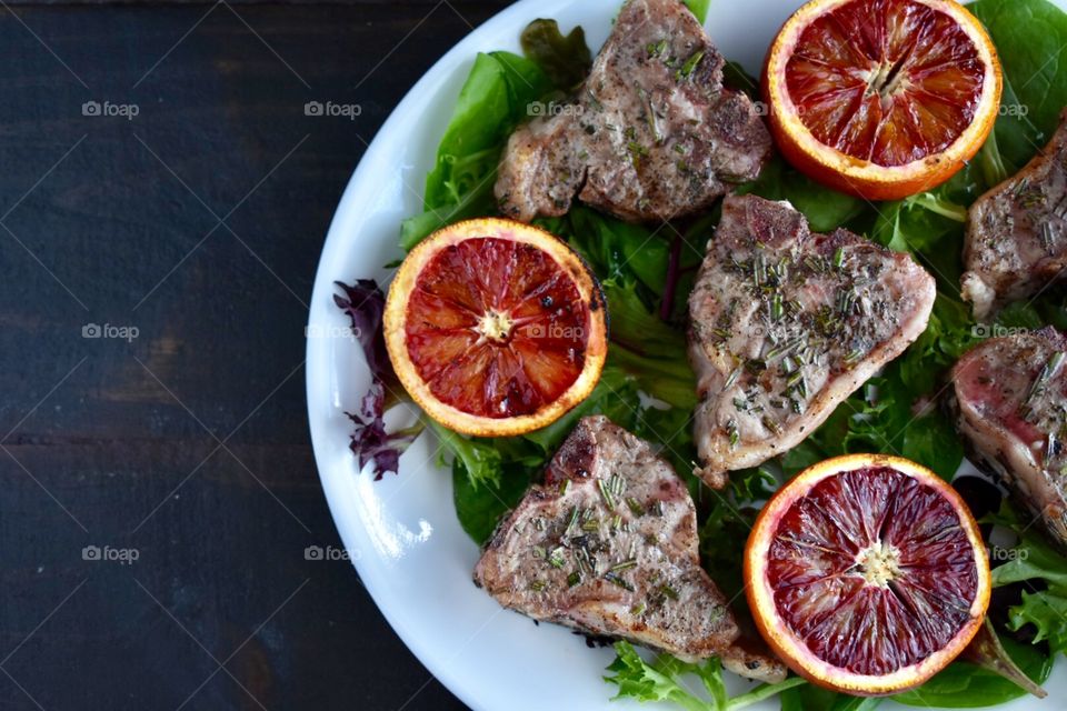 Grilled lamb loin chops and blood oranges on spring greens