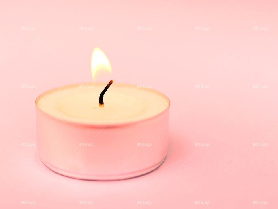 Close-up of candle against pink background