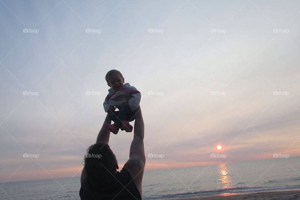 Father carrying her son at beach