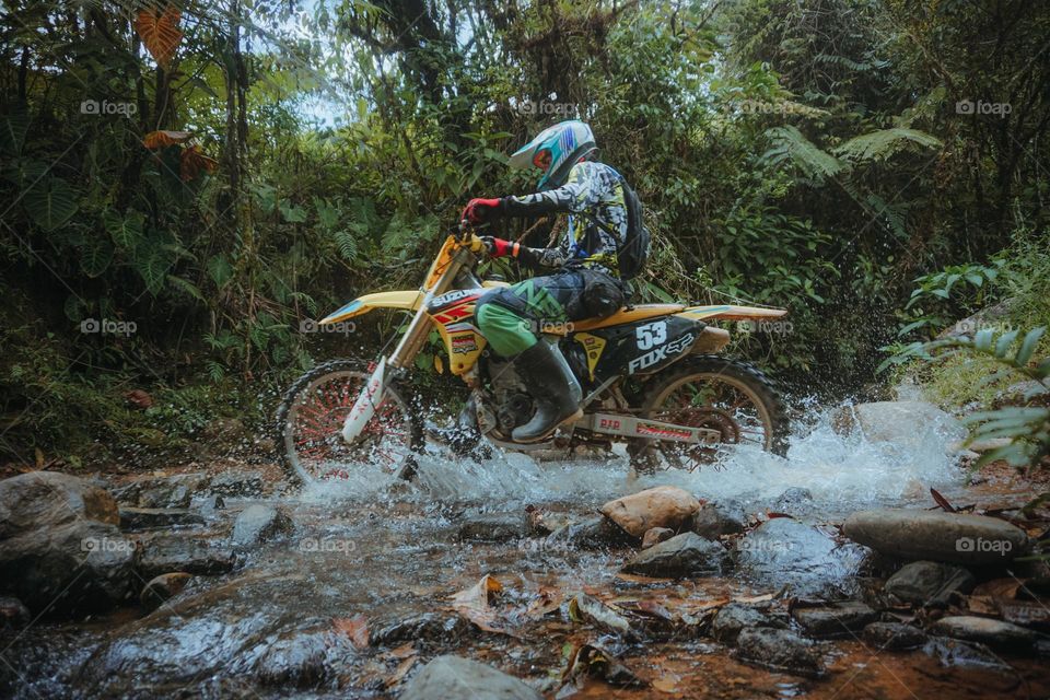 Motorcyclist in a competition crossing the river in an epic way