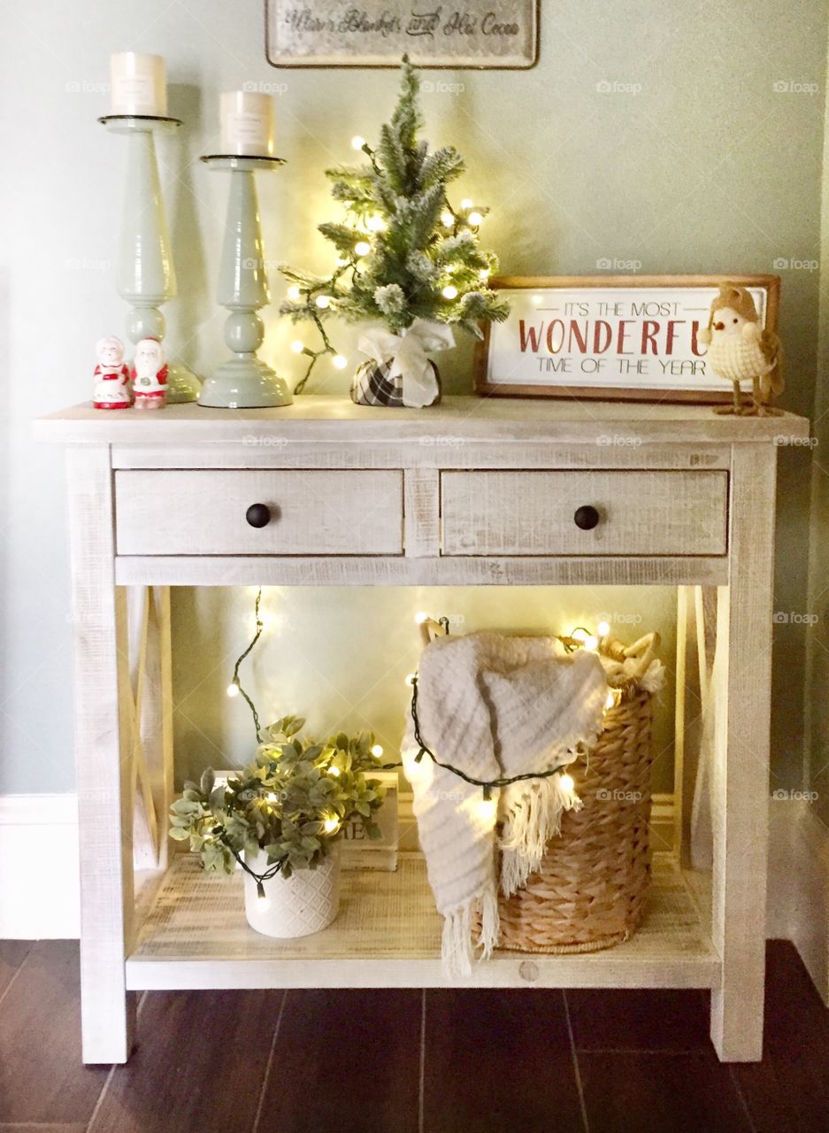 Christmas decorations on a table in the foyer of a home