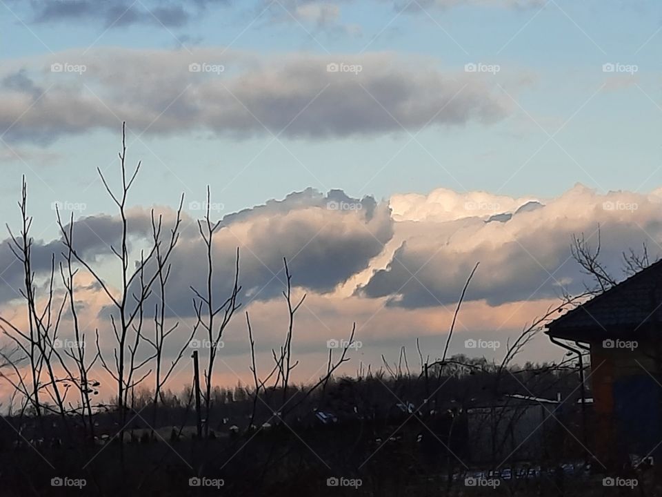 dark snow clouds against blue sky at sunset