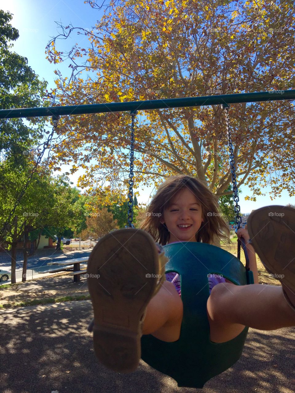 Happy girl enjoying swing on park