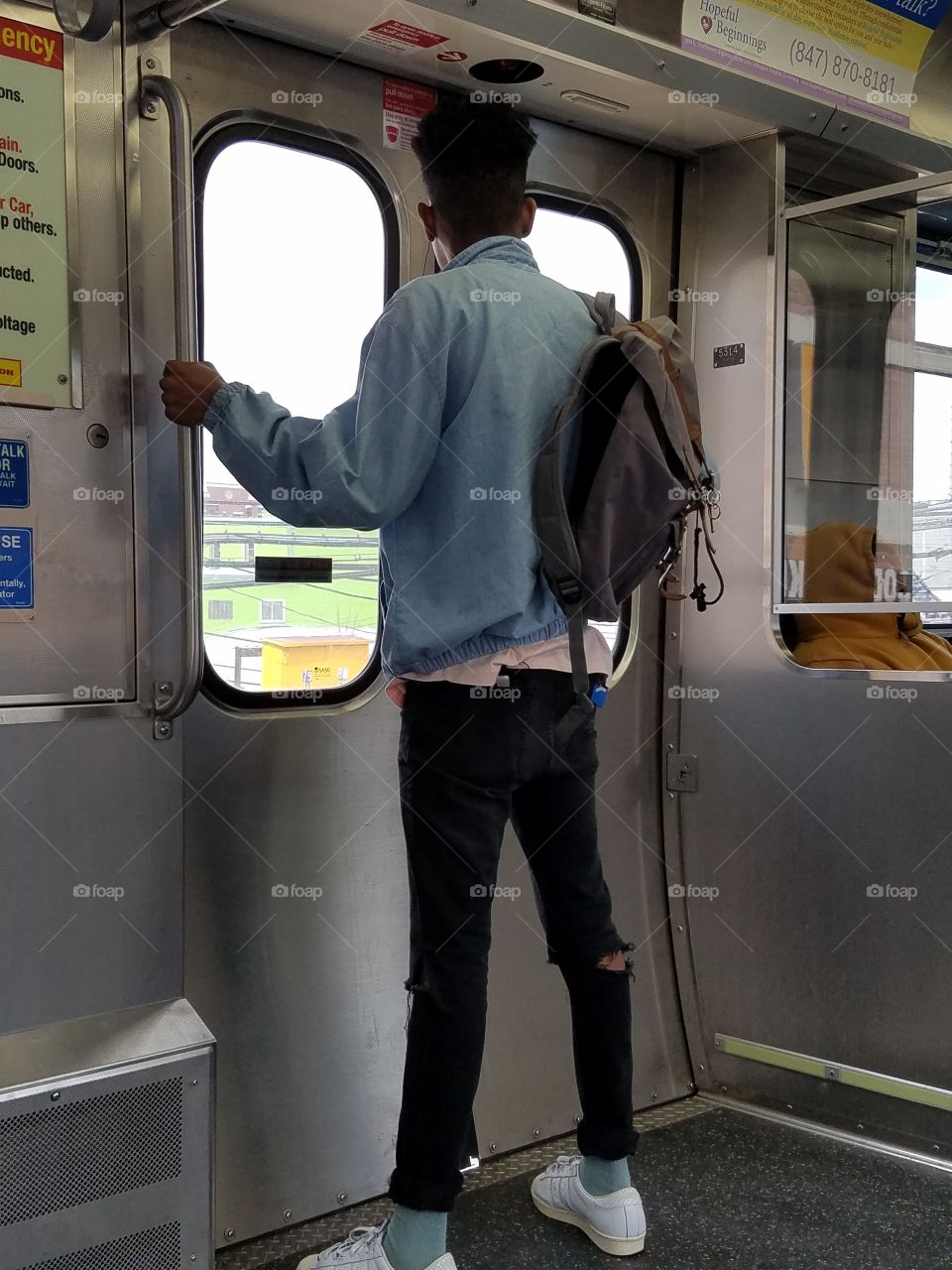 college student looking out train door window