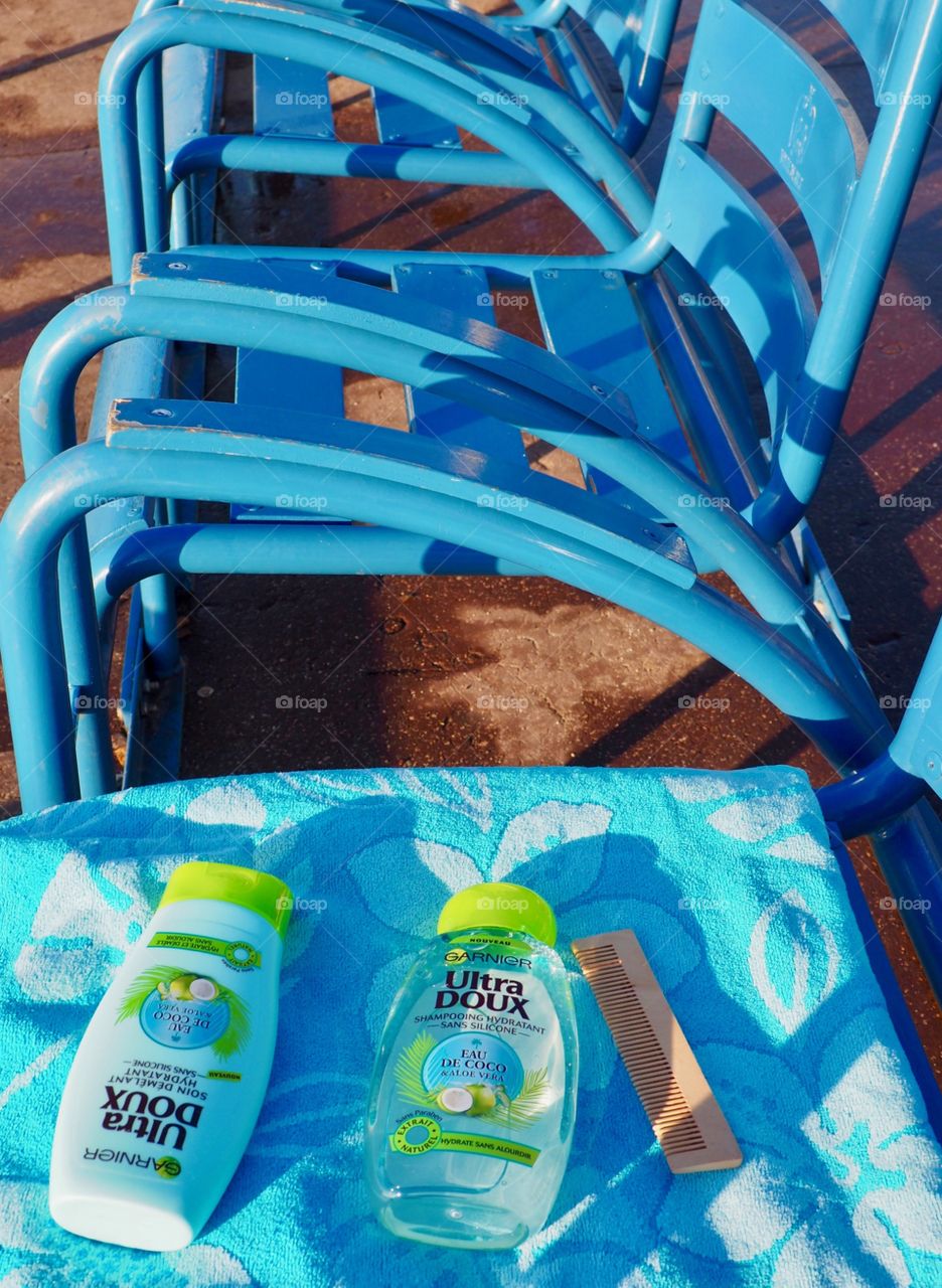 Garnier eau de coco on a blue beach towel on the blue chairs in Nice, France.