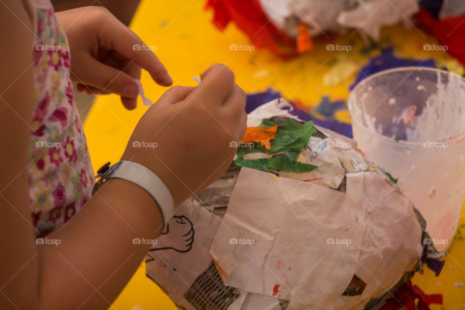 kid making a piñata with recycled paper