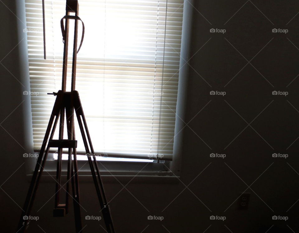 silhouetted easel next to window