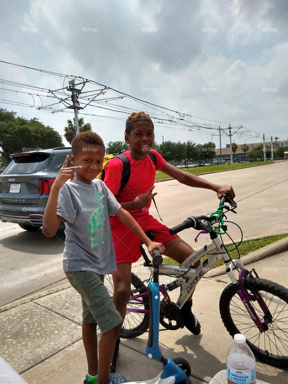Two brothers on the way to play at the neighborhood park. Both on their transportations 🚲🛴.