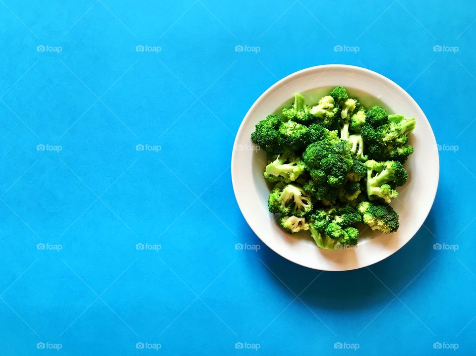 broccoli in a plate on a blue background