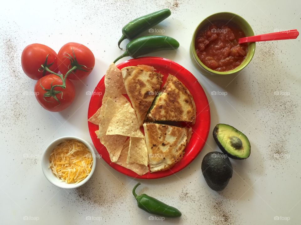 Delicious homemade quesadilla with tortilla chips, accompanied by ingredients. 