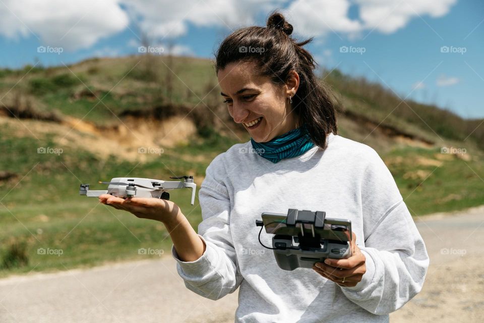 Woman playing with drone while on day roadtrip in nature.