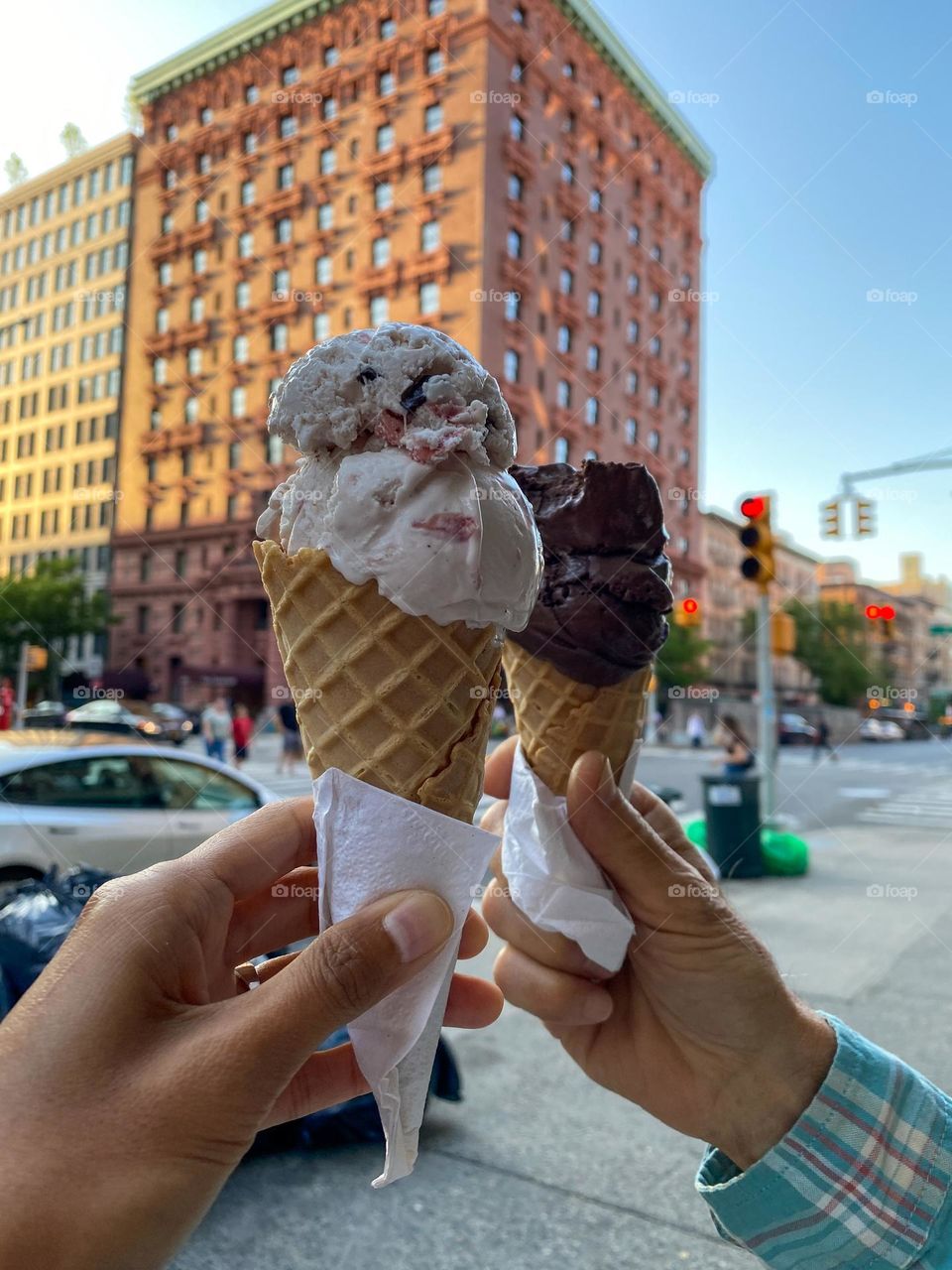 Two hands of a couple holding ice cream cone outdoors in the  Manhattan New York.