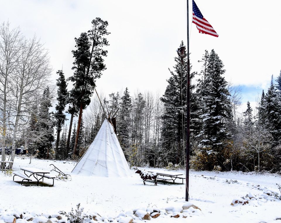 Flag Flies Over a Snow Covered Tepee
