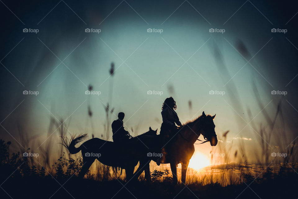 парень и девушка на лошадях на закате дня
