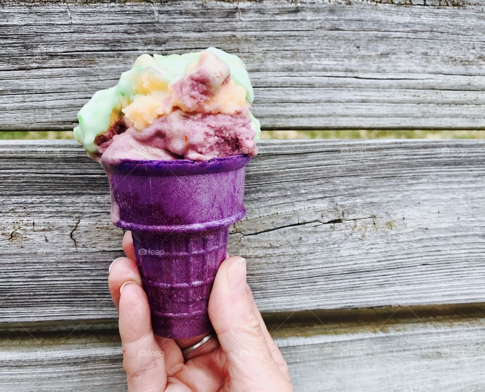 Person holding purple cone with ice cream