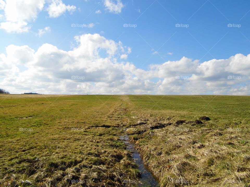Water in the middle of the meadow and beautiful blue sky