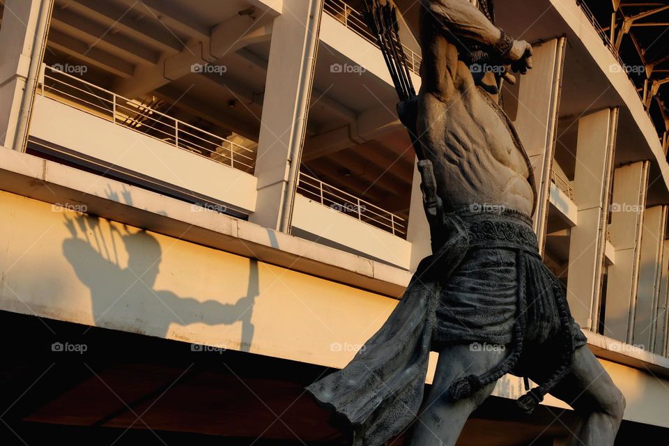 The shadow of the archer statue.