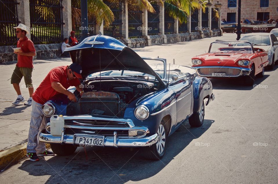 Antique autos in Cuba. This picture shows a blue 1958 Chevy Bel-Air convertible and red 1958 Ford Thunderbird.