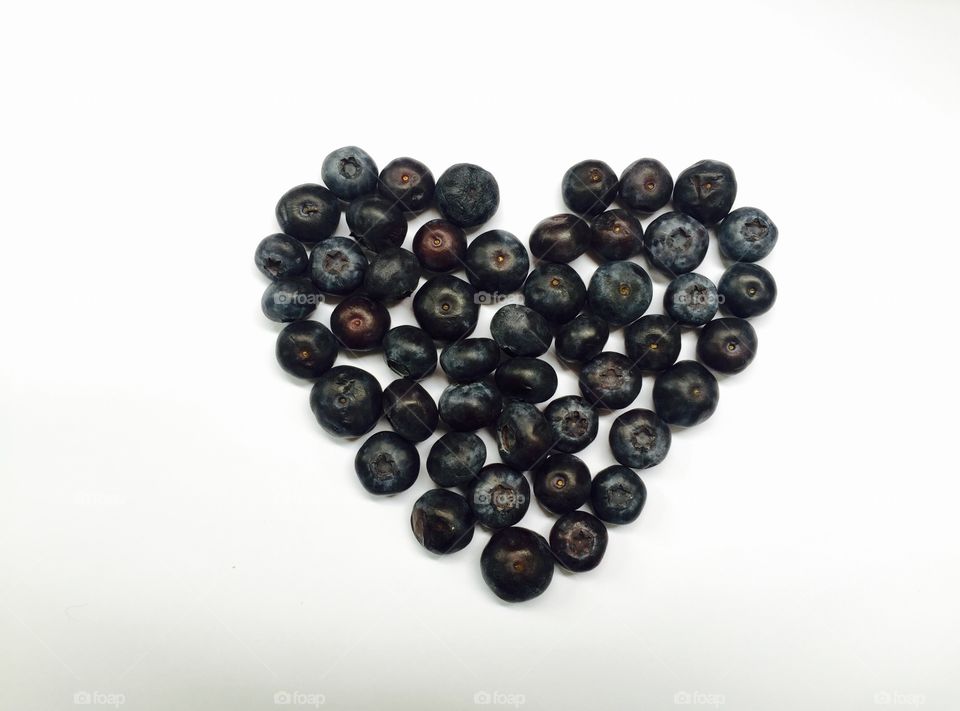 Heart made of blueberries on white background 