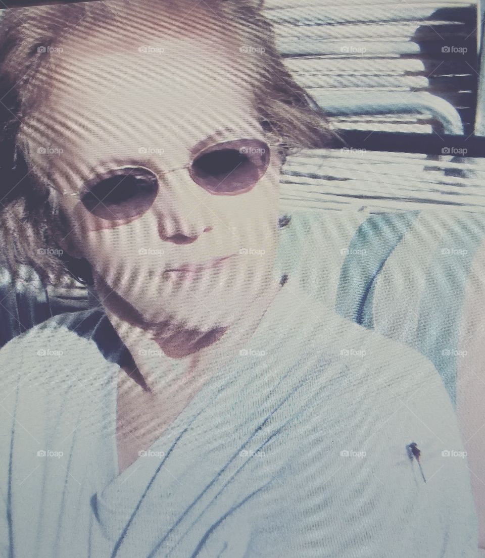 Early morning sun, dragonfly on shoulder, dark sunglasses on.