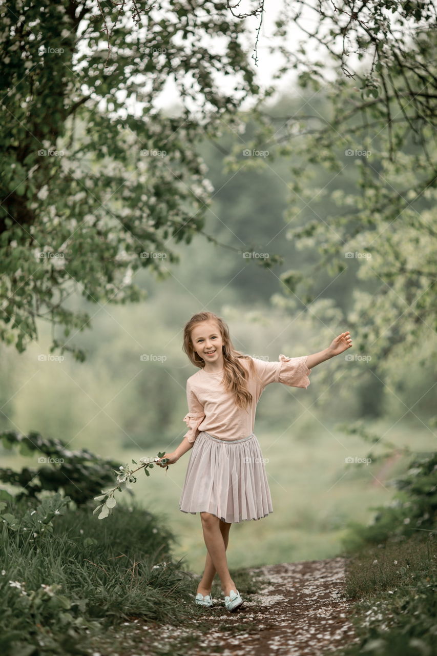 Girl in blossom garden at rainy day