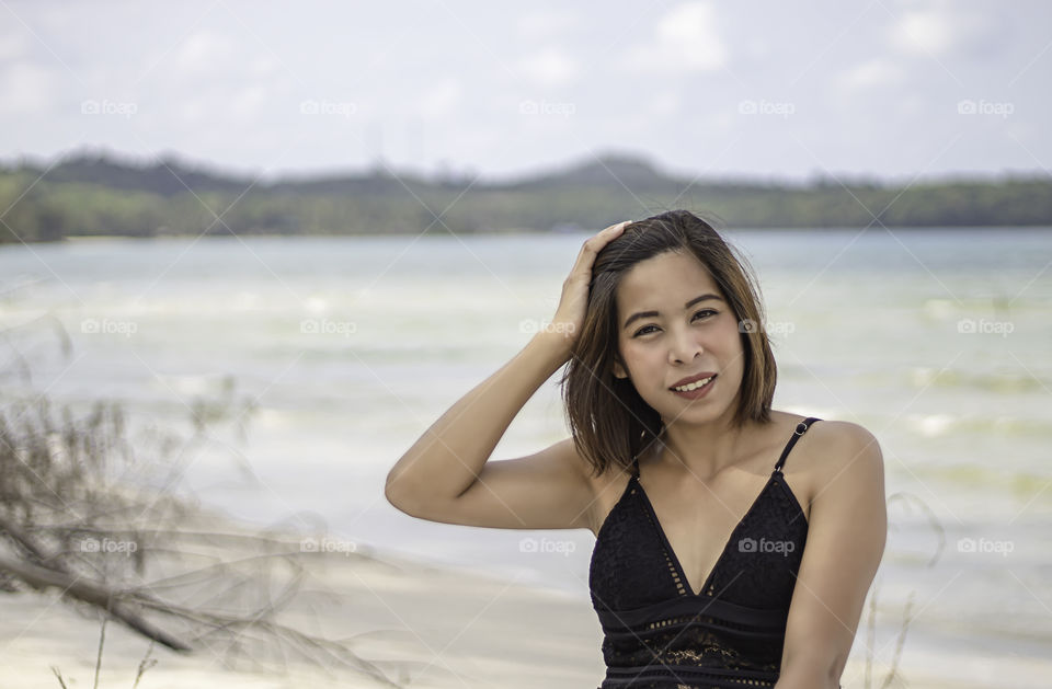 Portrait of Asian woman wearing a swimsuit background sea and sky