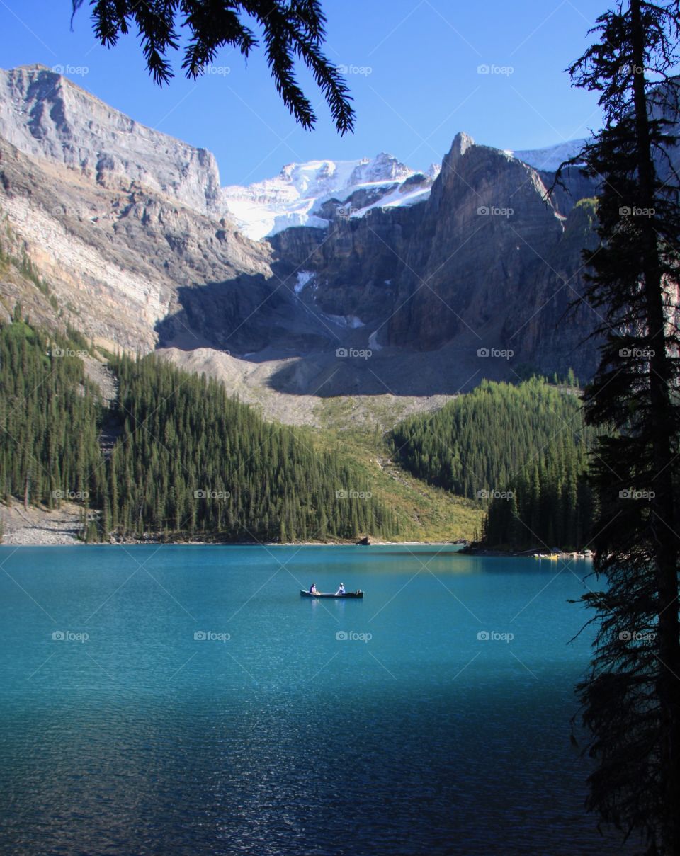 Canoeing on a beautiful lake beneath the majestic mountains of Banff National Park, Alberta