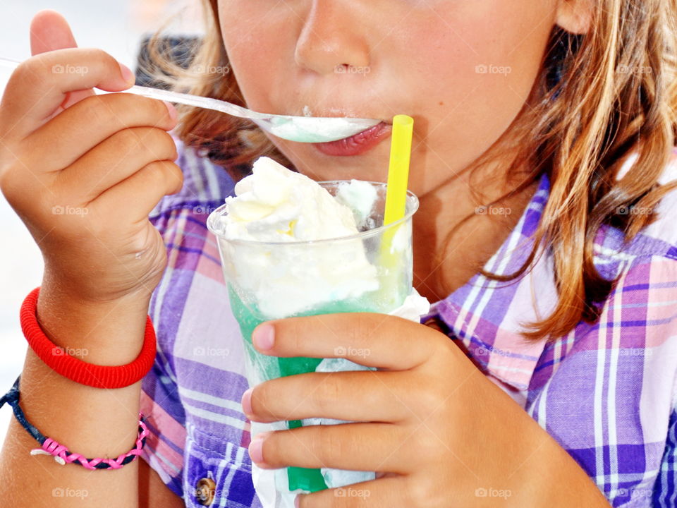 a little girl eating a granita