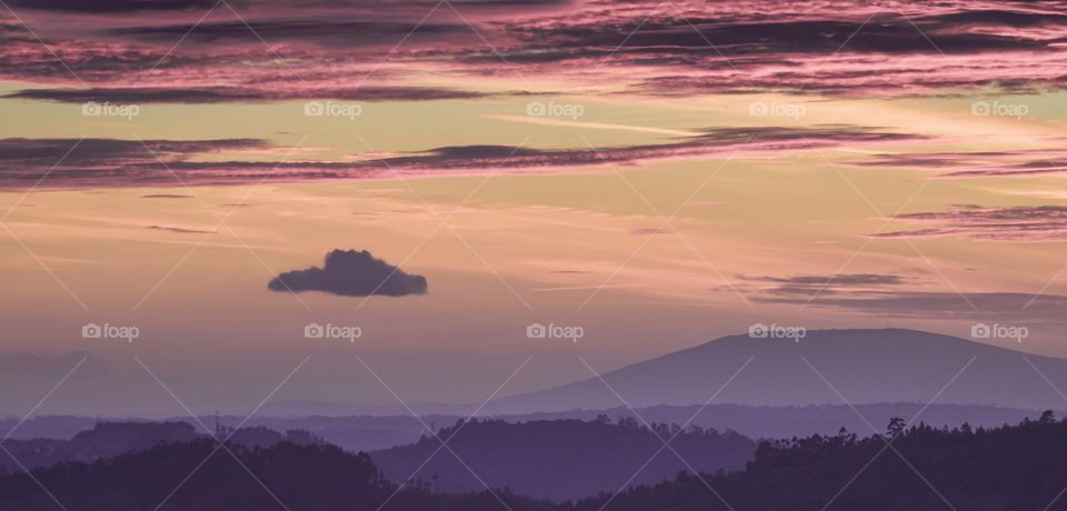 In the moments between sunset and blue hour, the misty tree covered hills appear purple and the sky has shades of violet