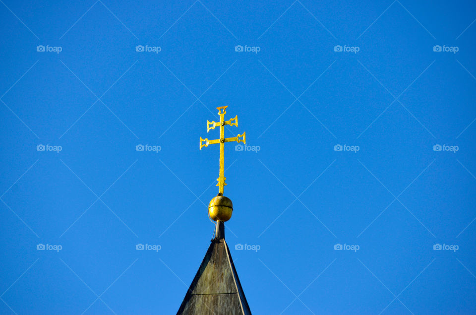 Golden cross on a steeple - church top double cross