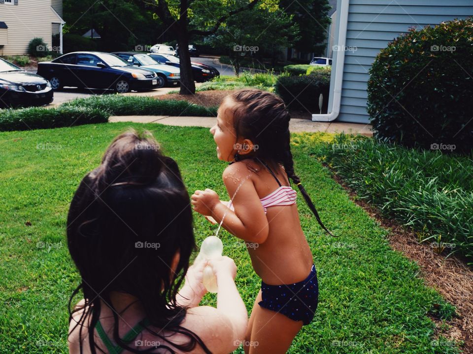 Two girls playing and splash with water in the park